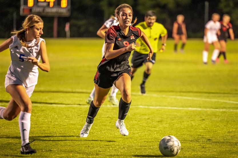 A soccer player runs with the ball